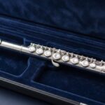 Silver flute in an open case with blue velvet lining