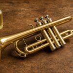 Brass student trumpet with a bottle of valve oil on a wooden table